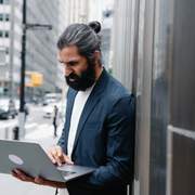arabic-businessman-standing-on-street-and-using-laptop-9623794
